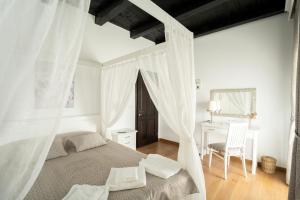 a bedroom with a bed with curtains and a desk at Pensiunea Cocosel in Căstău