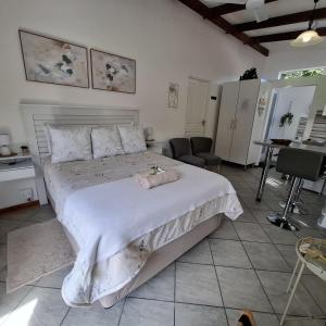a bedroom with a white bed with a stuffed animal on it at Sleep Haven Self-Catering Accommodation - Nelspruit in Nelspruit