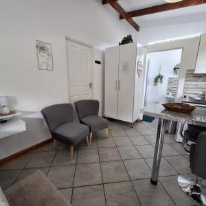 a kitchen with two chairs and a table at Sleep Haven Self-Catering Accommodation - Nelspruit in Nelspruit
