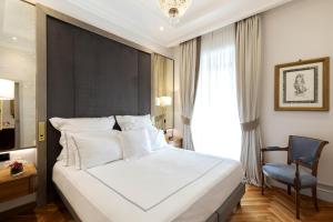 a bedroom with a large white bed and a chair at Grand Hotel Parker's in Naples