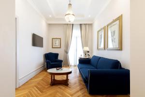 a living room with a blue couch and two chairs at Grand Hotel Parker's in Naples