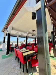a restaurant with red chairs and tables on a patio at Casa Coral Sulina in Sulina +26 photos
