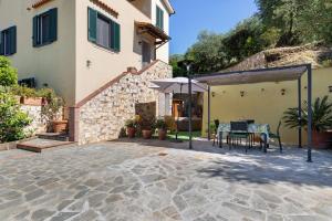 un patio di una casa con tavolo e ombrellone di La Dolce Vita a Quiesa