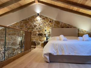 a bedroom with a bed with a stone wall at Downtown ViAlla in Chios +44 photos