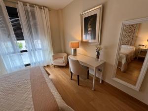 una camera da letto con scrivania, letto e specchio di Apartamento Jerez a Jerez de la Frontera