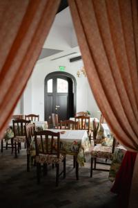 a dining room with tables and chairs and a window at Pensiunea Cocosel in Căstău