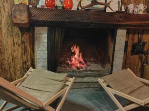 two chairs sitting in front of a fireplace at Rustico Cascina Val Malvaglia in Malvaglia