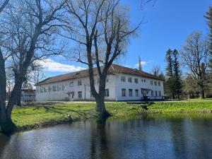 a large white building next to a river at Raasiku majutus in Raasiku