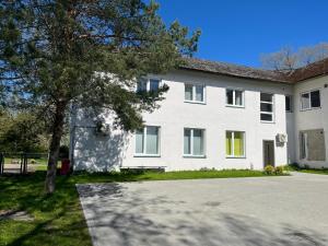 a white house with a tree in front of it at Raasiku majutus in Raasiku +30 photos