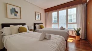 a bedroom with two beds and a window at VISTAS MAR Y PUERTO Plentzia - 200m2 y Parking in Plentzia