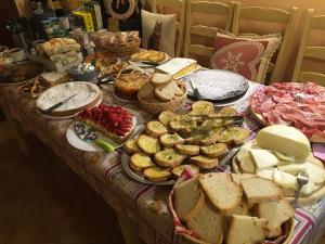 einen Tisch mit vielen verschiedenen Lebensmitteln in der Unterkunft Agriturismo Il Paradiso in Asciano