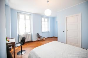 - une chambre avec des murs bleus, un lit et deux chaises dans l'établissement Appartamento in Villa Fioravante by Wonderful Italy, à Moltrasio