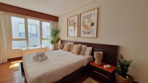 a bedroom with a large white bed with a window at VISTAS MAR Y PUERTO Plentzia - 200m2 y Parking in Plentzia