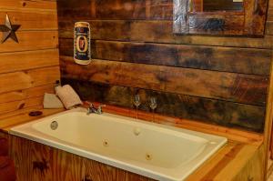 eine Badewanne in einem Badezimmer mit Holzwänden in der Unterkunft Secluded Log Cabin for a Romantic Getaway near Maggie Valley, North Carolina in Cherokee
