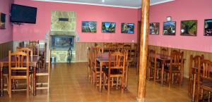 a dining room with tables and chairs and a fireplace at Albergue Aurora Boreal in Casas del Monte