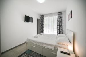 a white bedroom with a bed and a window at Sery Apartment Resort Alz in Mamaia Sat/Năvodari +31 photos