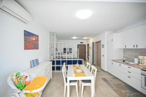 a kitchen with a table and chairs in a room at Sery Apartment Resort Alz in Mamaia Sat/Năvodari