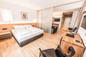 una camera da letto con un letto, una scrivania e una televisione di Göttfried - essen trinken schlafen a Linz