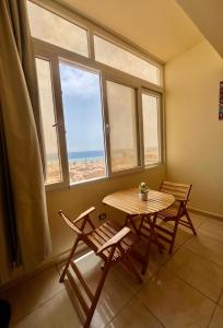a table and chairs in a room with a window at Tree House Hotel Dahab in Dahab
