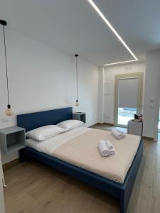 a bedroom with a large bed with two towels on it at AZ rooms in Noto