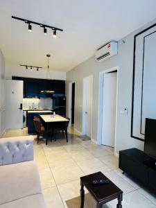 a living room with a table and a kitchen at The KLCC Suites At Axon Residence in Kuala Lumpur