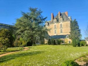una grande casa con un grande prato di Les Jardins de l'Orangerie a Durtal