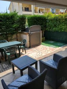 a patio with a table and chairs and a grill at Villetta Imola in Lido degli Estensi