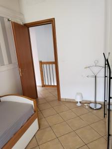 a bedroom with a bed and a tiled floor at Villetta Imola in Lido degli Estensi +22 photos