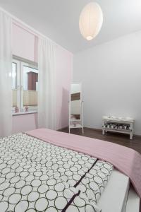 - une chambre avec un lit doté d'un couvre-lit rose et blanc dans l'établissement Iva Mare, à Darłówko