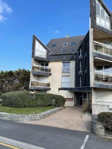 a large apartment building with a driveway in front of it at Appartement Ô Nid Perché Vue mer in Agon Coutainville