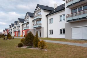 a row of apartment buildings with a yard at Iva Mare in Darłówko