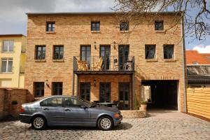 a car parked in front of a brick building at Hagemeisterensemble in Werder