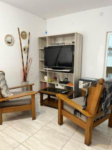 a living room with two chairs and a large television at Casa en Santa Rosa in Santa Rosa
