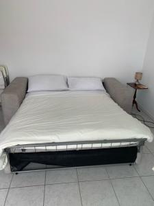 a bed sitting in a room with a couch at La Stella Marinella in Santa Marinella