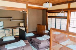 a room with two bunk beds and two windows at Koya Backpackers in Karuizawa