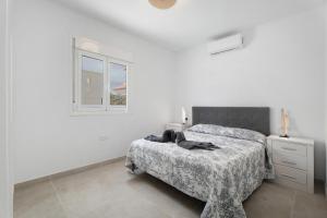 a white bedroom with a bed and a window at Villa Violeta in Costa Del Silencio +23 photos