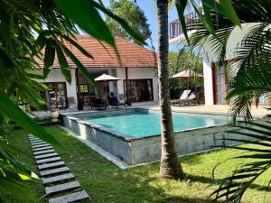 a swimming pool in front of a house at Villa Light - Amed Bali in Amed