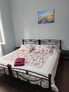 a bed with a pink and white quilt on it at Apartment Atiki metro shared bathroom and kitchen in Athens