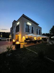 a building with tables and umbrellas in front of it at K&T Estates Resort & Spa, Frankfurt in Liederbach am Taunus
