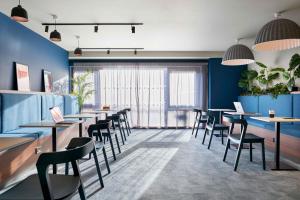 een restaurant met blauwe muren en tafels en stoelen bij Argyl - Westfield Summer Budget Accommodation, Adults Only in Edinburgh