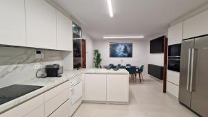 a kitchen with white cabinets and a table in it at VISTAS MAR Y PUERTO Plentzia - 200m2 y Parking in Plentzia +39 photos