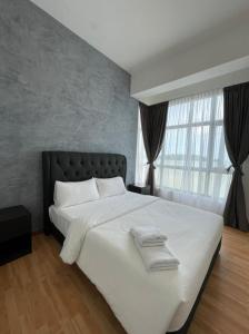 a bedroom with a large bed with white sheets at SwissBelResidence Studio With King Bed in Kuantan