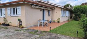 a house with a patio with a table in the yard at 45Quiri in Mont-de-Marsan