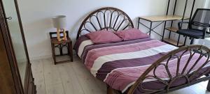 a bed in a room with a chair and a table at 45Quiri in Mont-de-Marsan