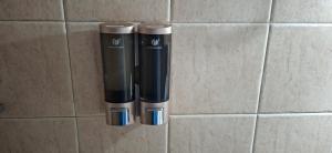 two black and silver objects on a tile wall at Angels' House in Thessaloniki