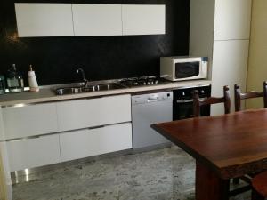 cocina con fregadero, microondas y mesa en Pellico Apartment, en Brusaporto