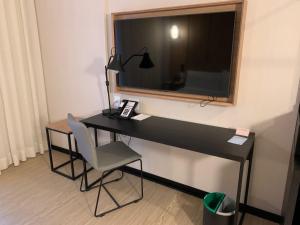 a desk with a television and a chair in a room at Radisson Pinheiros in São Paulo