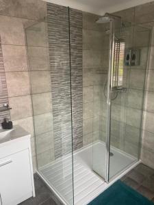 a shower with a glass door in a bathroom at Camaraderie Guest House in York