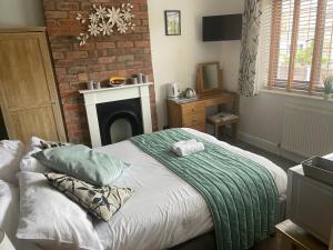 a bedroom with a bed and a brick wall at Camaraderie Guest House in York
