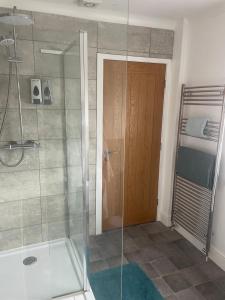 a bathroom with a shower with a glass door at Camaraderie Guest House in York